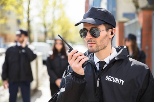 portrait of a male security guard talking on walkie talkie